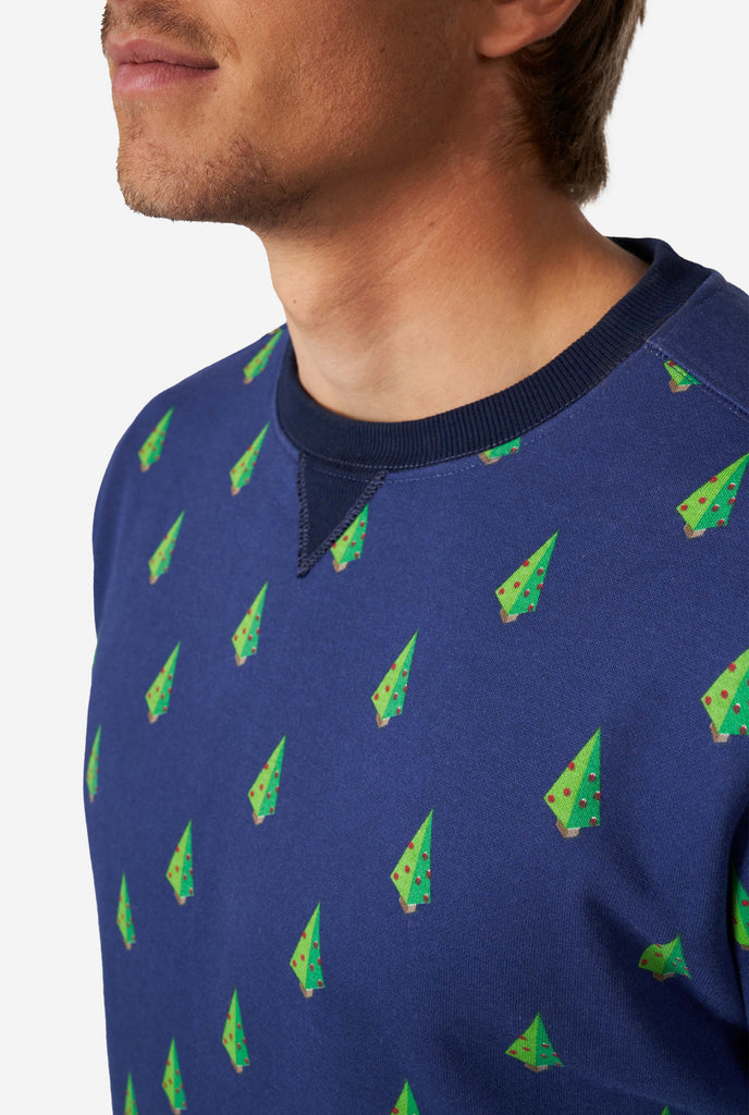 Man wearing blue Christmas sweater with Christmas tree print, close up