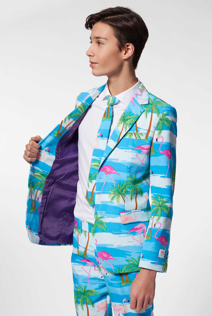 Teen wearing light blue suit with flamingo palm tree print