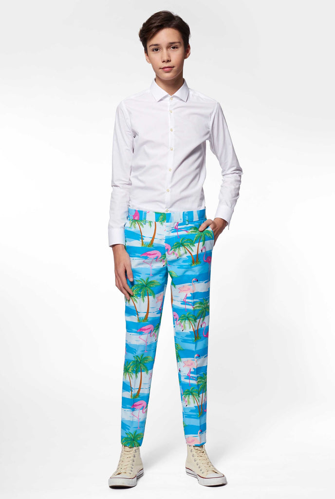 Teen wearing light blue suit with flamingo palm tree print, pants view