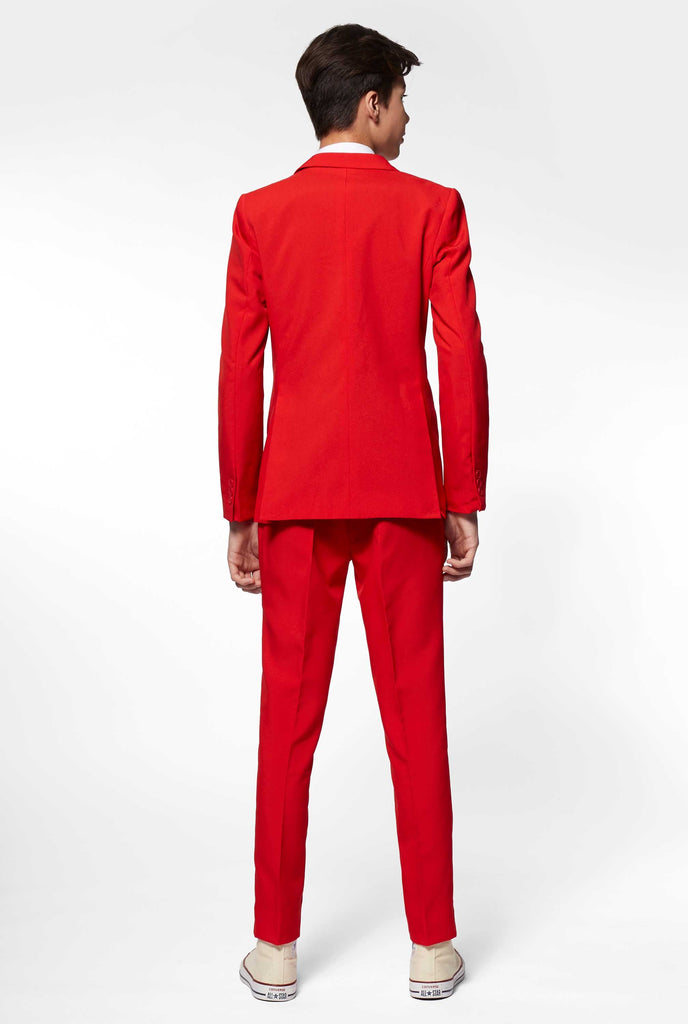 Teen wearing red formal suit, view from the back