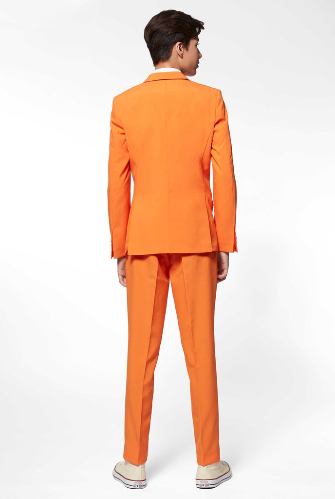 Teen wearing orange formal suit, view from the back